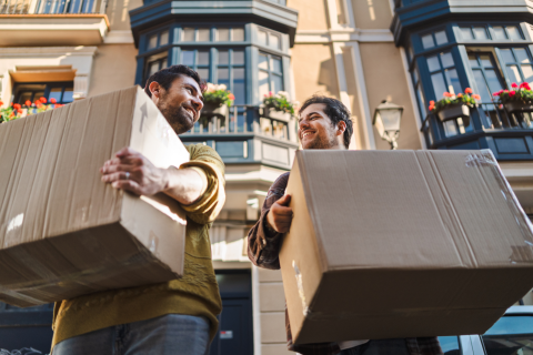 Two Men Moving Boxes and Smiling, Handling Panic Disorder When Moving to a New City